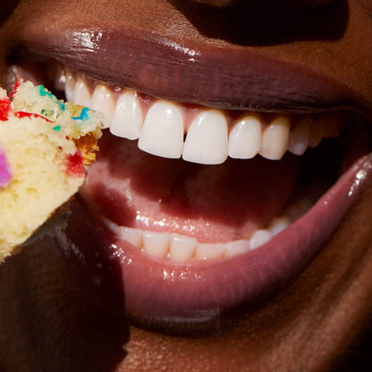 [Shared: A close up of a model wearing Tower 28 Beauty's LipSoftie™ Lip Treatment in Confetti Cake on her lips]