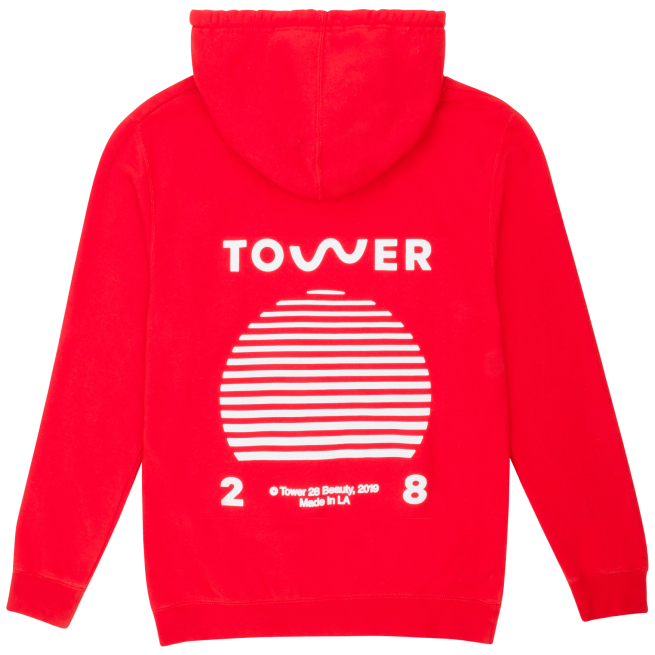 [Shared: A flat lay image of Tower 28 Beauty's SOS Hoodie in sunset orange where all proceeds are donated to Heal The Bay.]