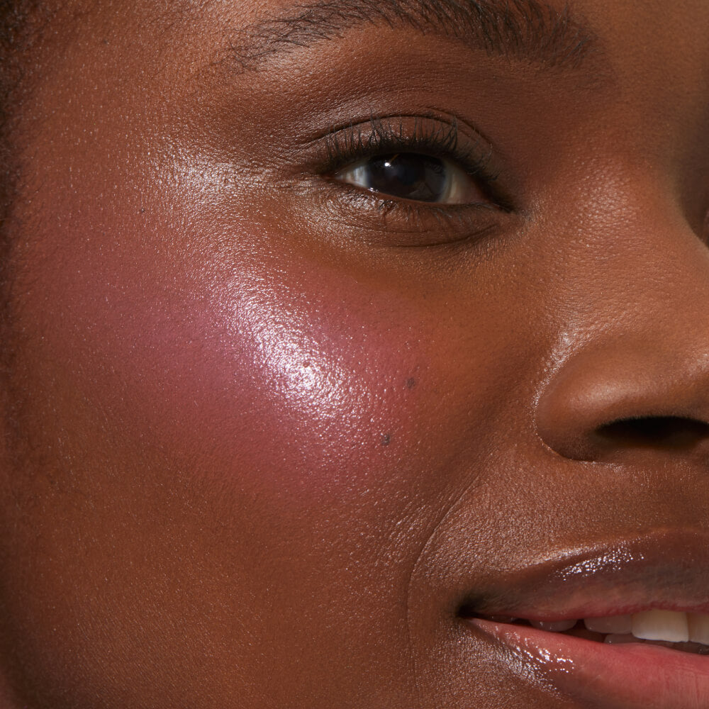 A close up of a model with Tower 28 Beauty's BeachPlease Cream Blush in Dream Hour on her face.
