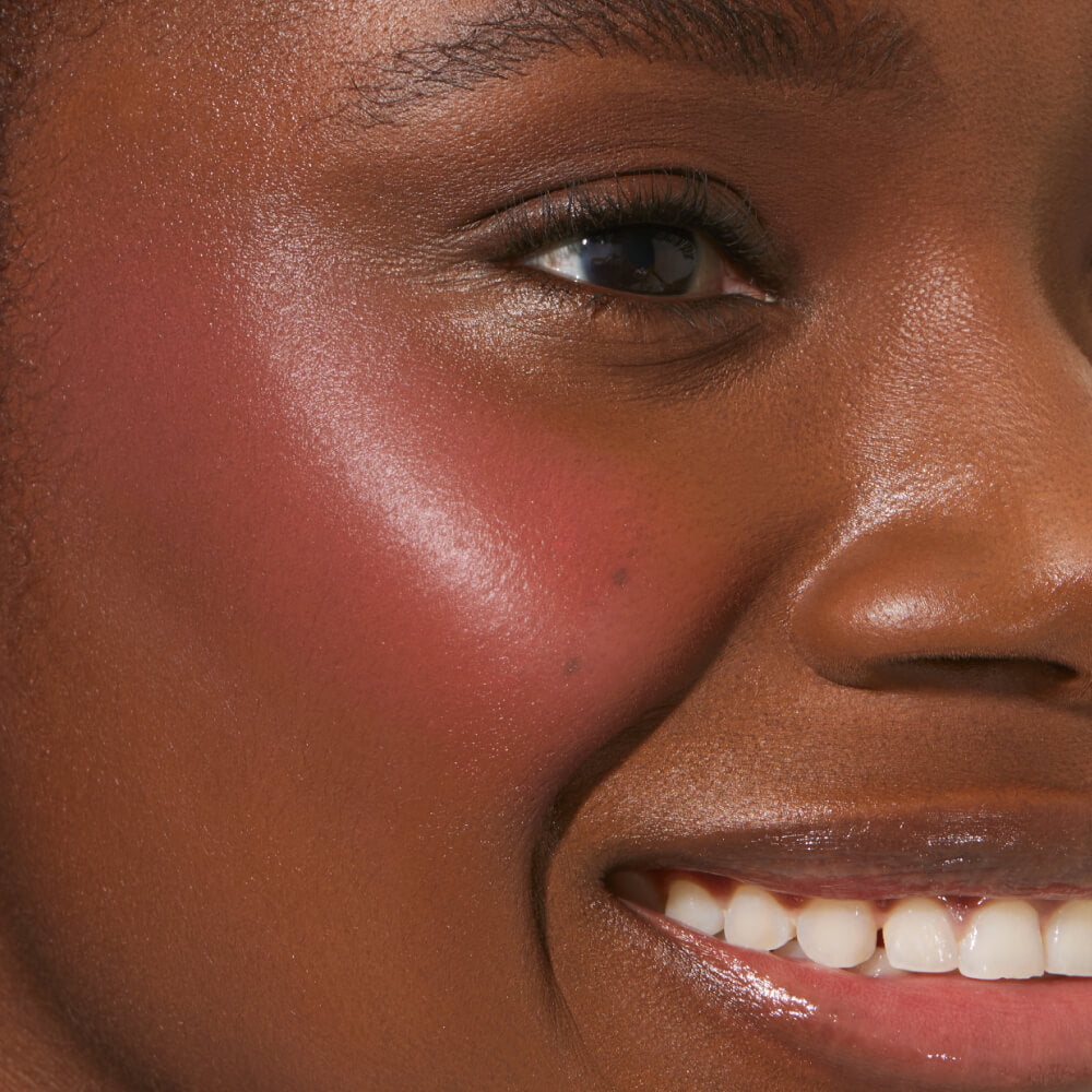 A close up of a model with Tower 28 Beauty's BeachPlease Cream Blush in Happy Hour on her face.