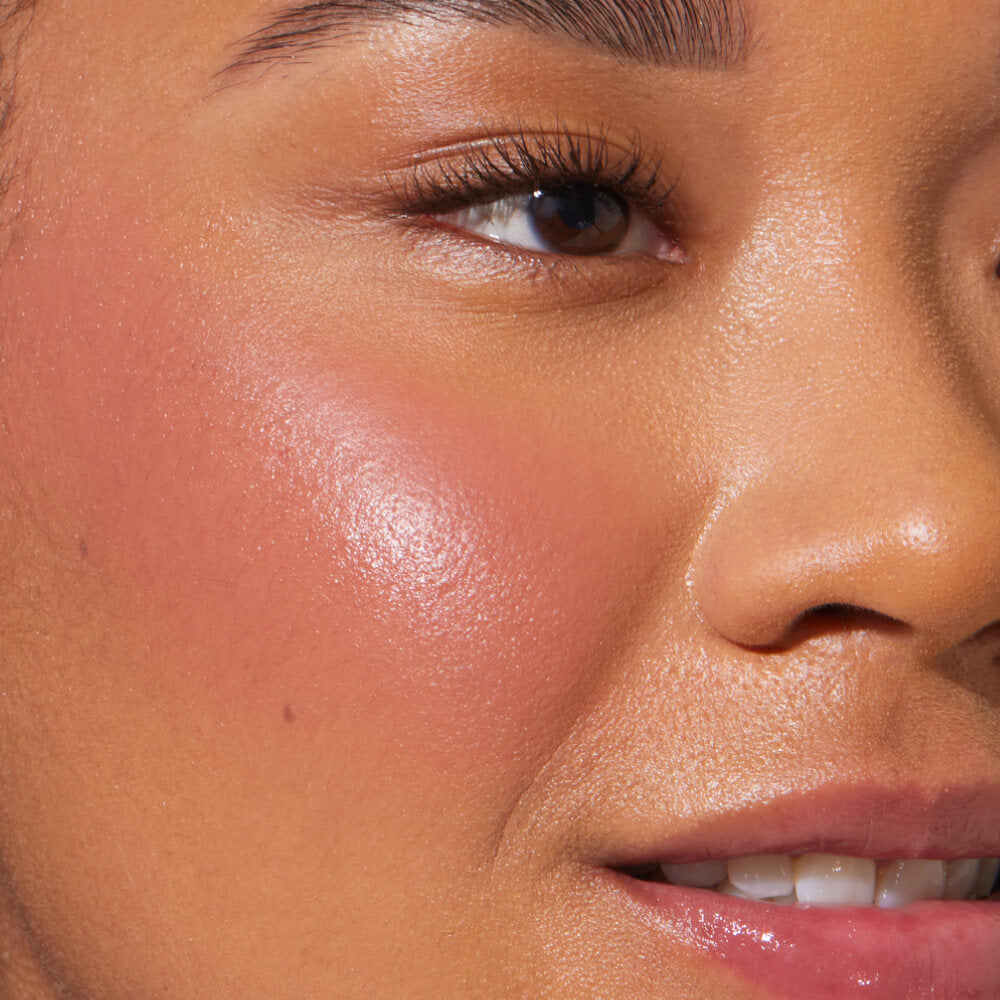 A close up of a model with Tower 28 Beauty's BeachPlease Cream Blush in Office Hours on her face.