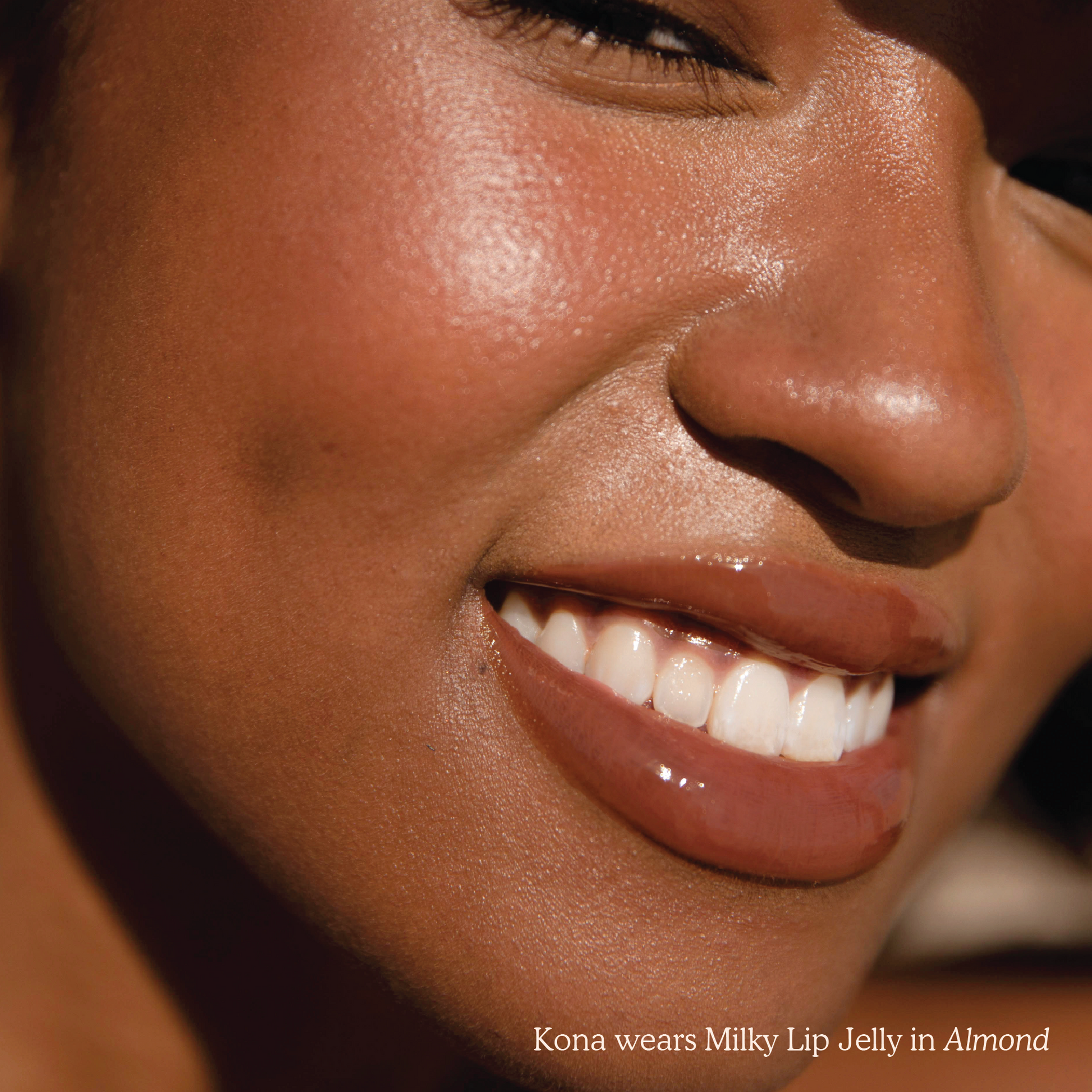 [Shared - Closeup photo of a girl with very glossy lips, wearing the Tower 28 Beauty ShineOn Milky Lip Jelly shade in Almond (a milky chocolate-brown)