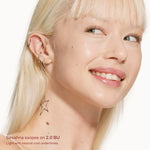 Close-up of a woman with blonde hair and visible ear, wearing earrings on a white background. [2.0 BU]