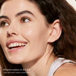 Close-up of a woman's face with a focus on her skin texture, wearing a light-colored top. [3.0 CC]