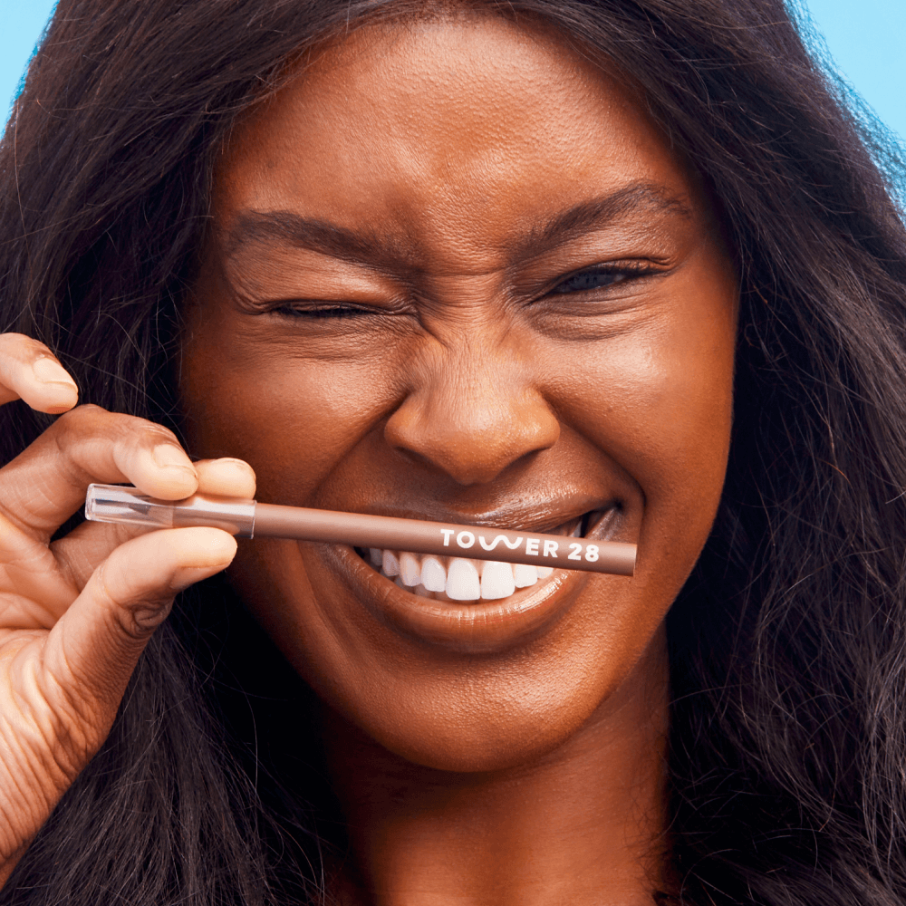A person wearing the Tower 28 Beauty OneLiner in the shade Color Me Fine on her lips, cheeks, and eyes. [Color Me Fine]