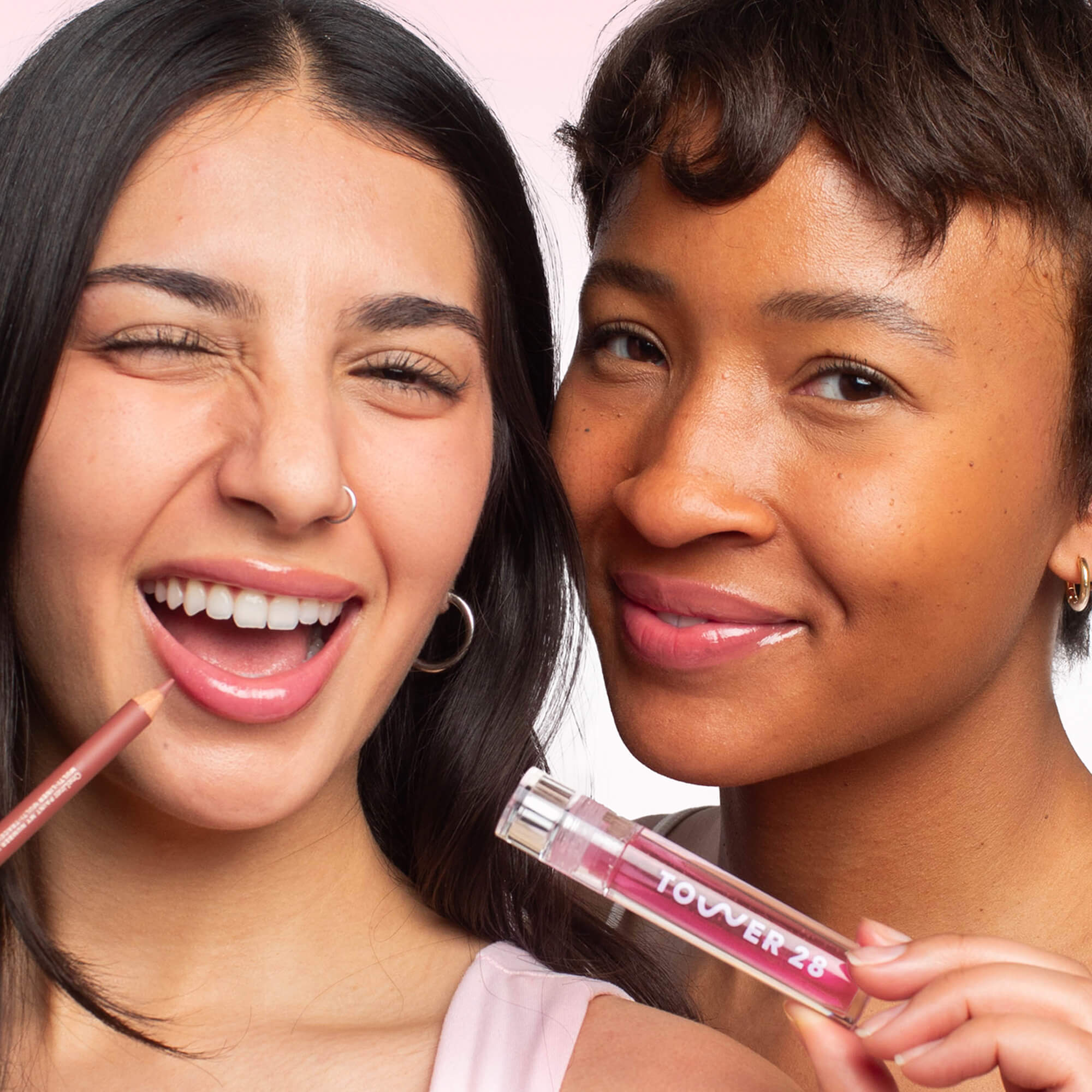 [Shared: This image features two models showcasing the Tower 28 Line + Shine Lip Kit. On the left, the model is applying a lip liner, while the model on the right is holding a tube of lip gloss. Both women are smiling and wearing the products, with both sporting a glossy, pinky-nude lip look.]