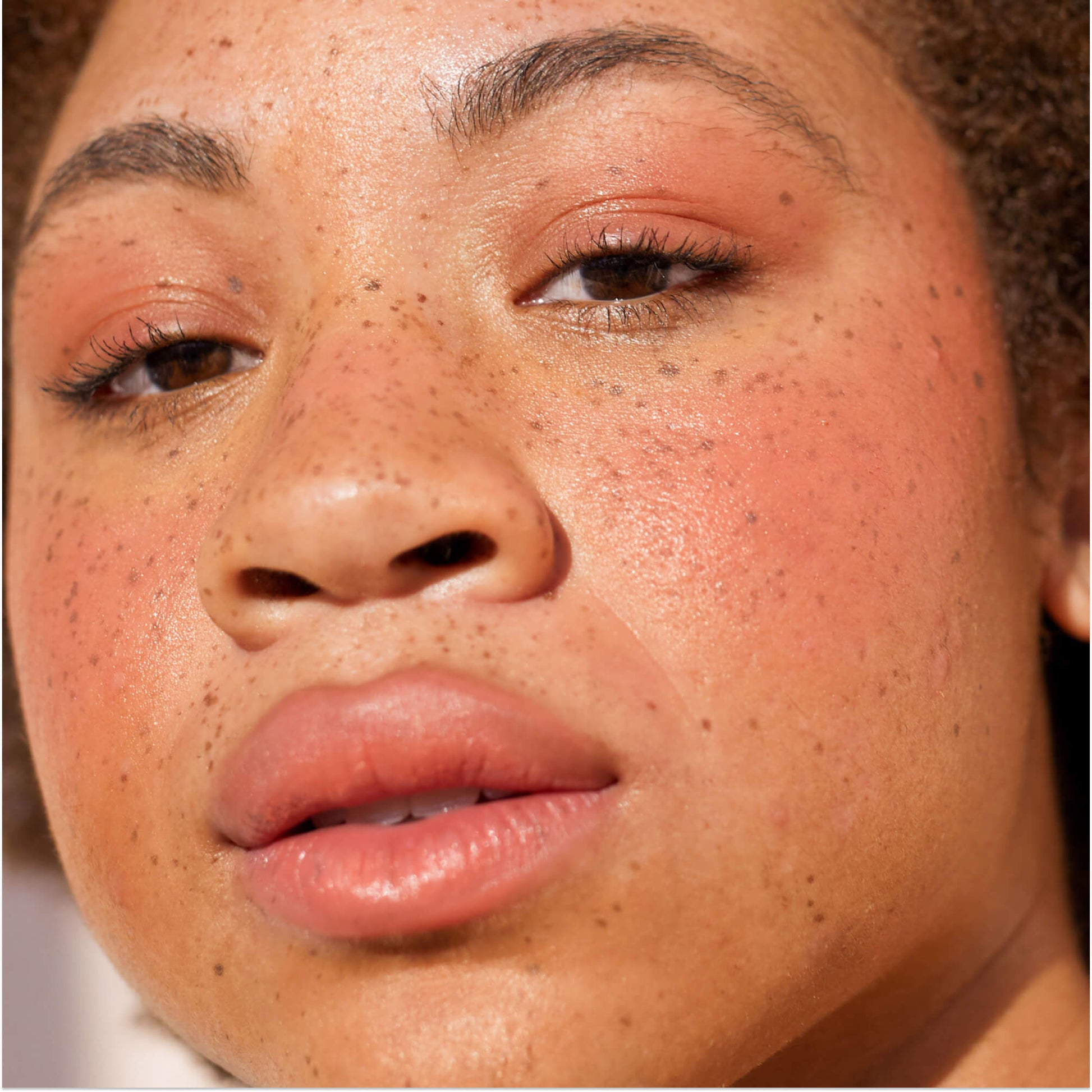 A close up of a model with Tower 28 Beauty's BeachPlease Cream Blush in Rush Hour on her face.