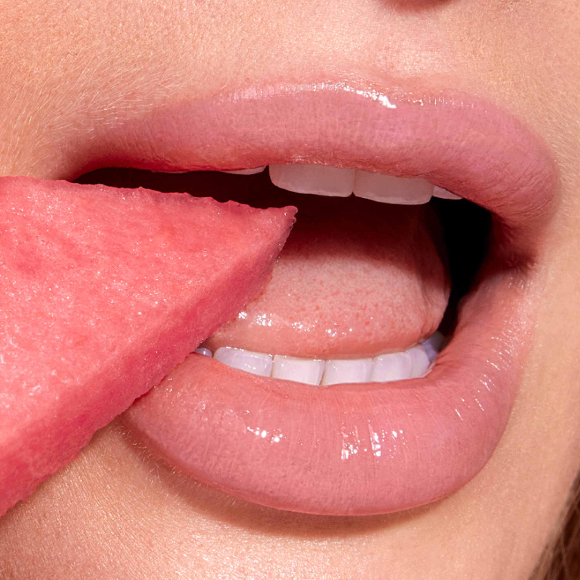 A close up of a model wearing Tower 28 Beauty's LipSoftie™ Lip Treatment in Watermelon Kiwi on her lips. [Watermelon Kiwi]