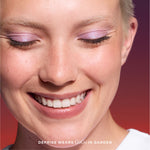 Close-up of a woman's face with pink eye makeup and a blurred background [Garden]