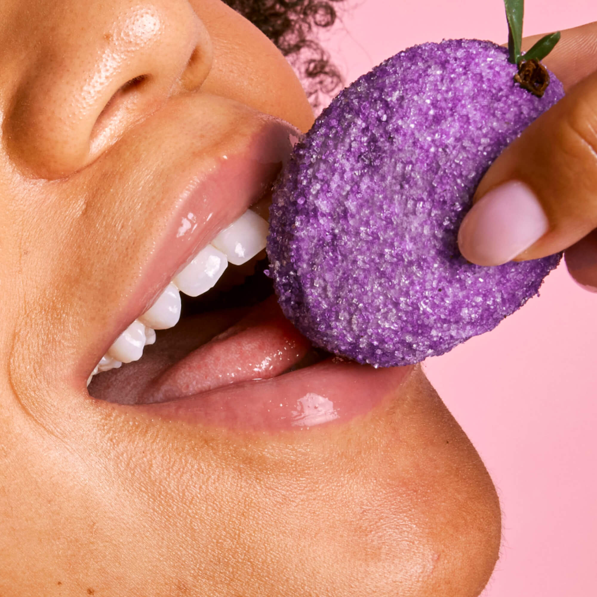 A close up of a model wearing Tower 28 Beauty's LipSoftie® Lip Treatment in Sugar Plum on her lips. [Sugar Plum]