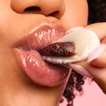 A close up of a model wearing Tower 28 Beauty's LipSoftie® Lip Treatment in Red Bean Mochi on her lips. [Red Bean Mochi]