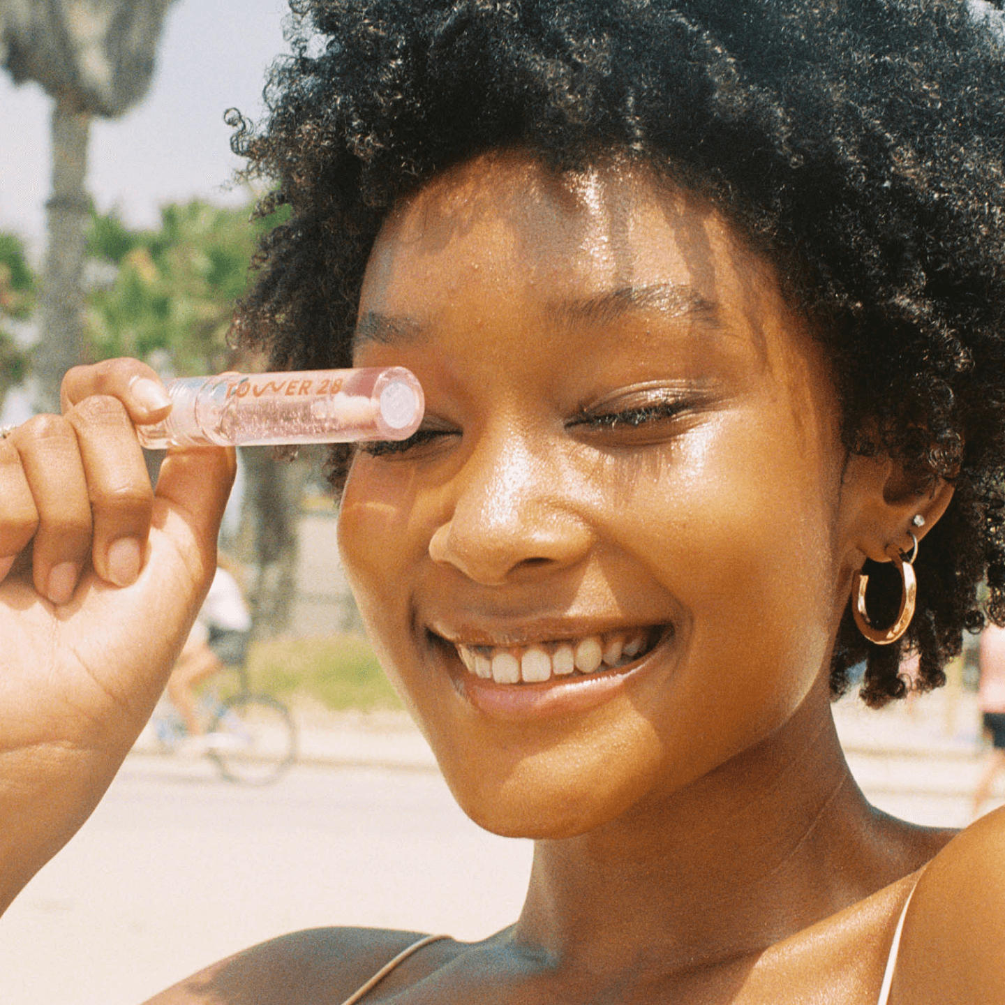 [A model holding up Tower 28 Beauty ShineOn Lip Jelly in the shade Chill.]