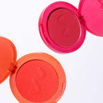 Two open blush compact cases, one red and one orange, on a white background. [Shared]