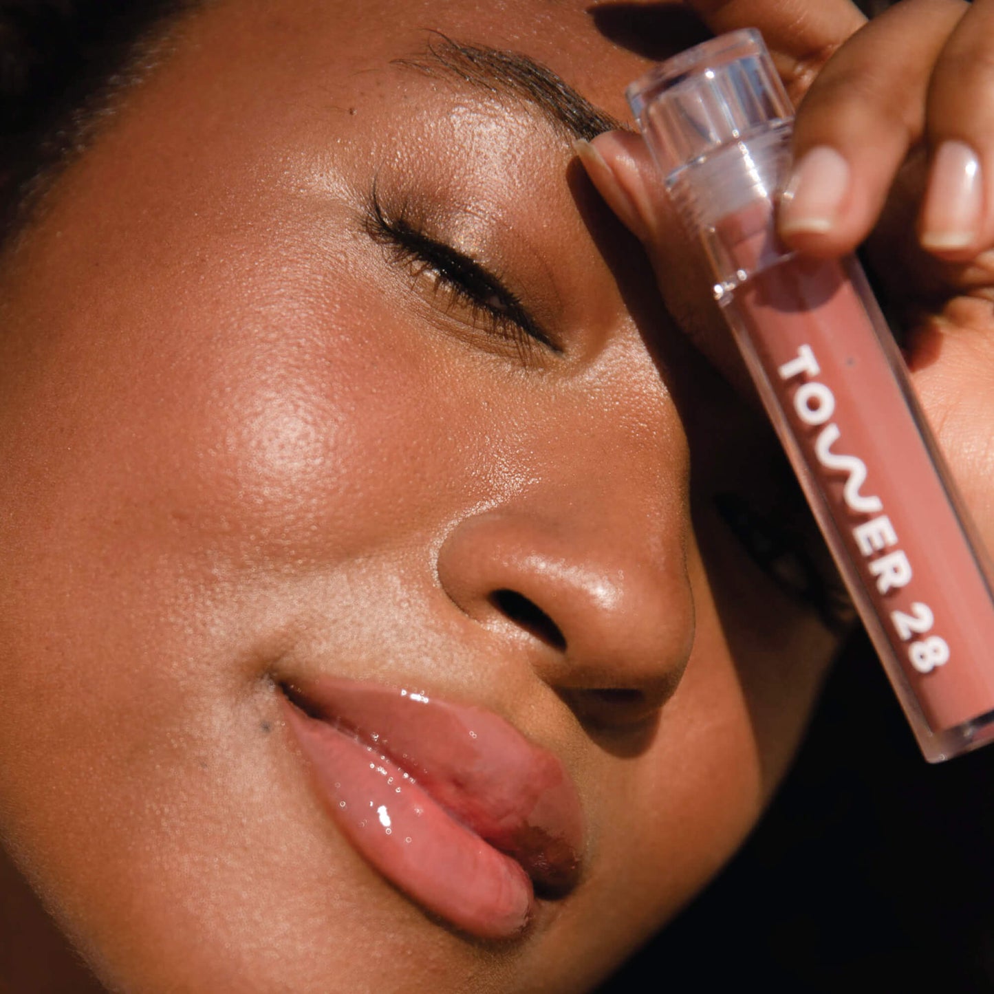 Cashew [A model wearing the Tower 28 Beauty ShineOn Lip Jelly in the shade Cashew on her lips]