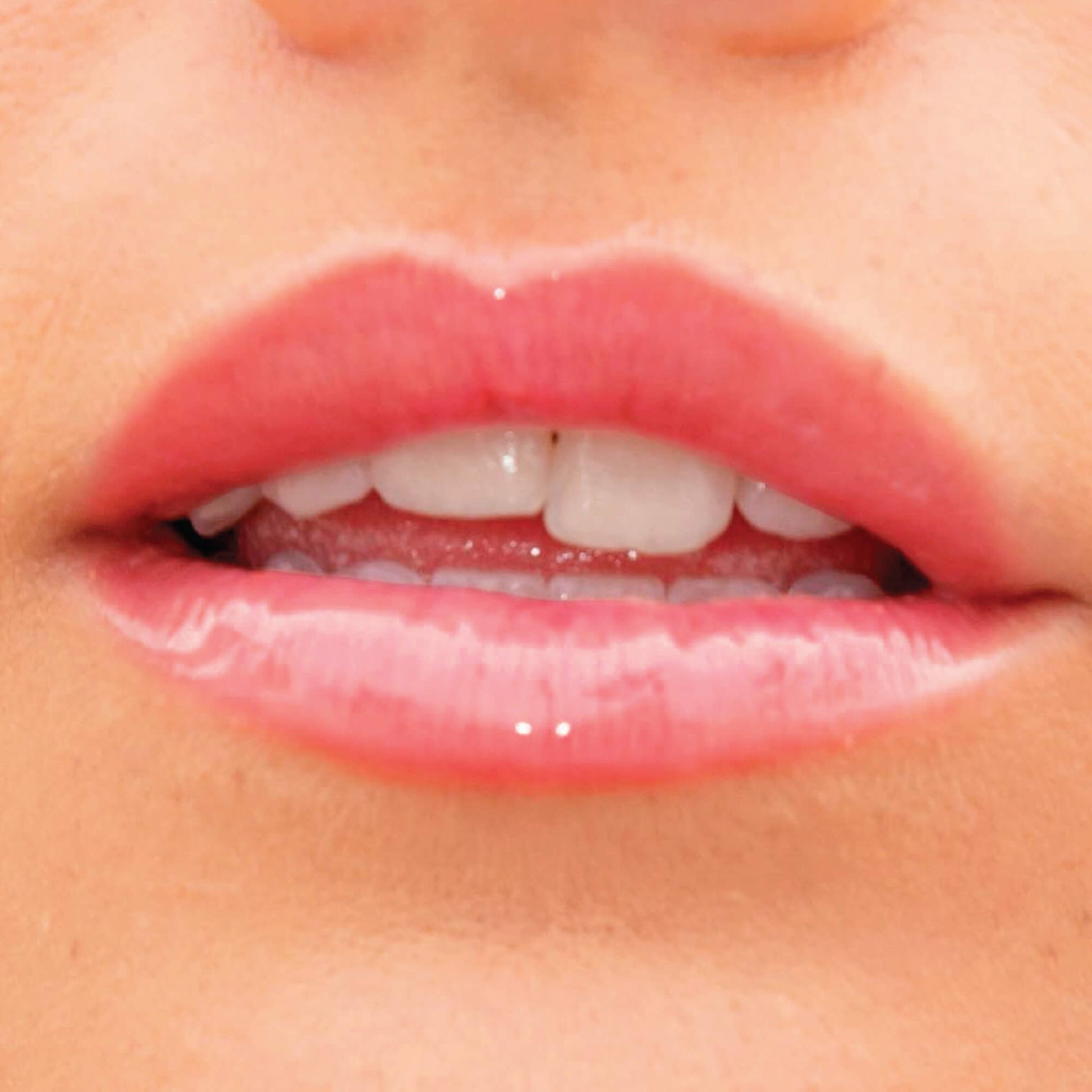 A model wearing the Tower 28 Beauty ShineOn Lip Jelly in the shade Coconut on her lips