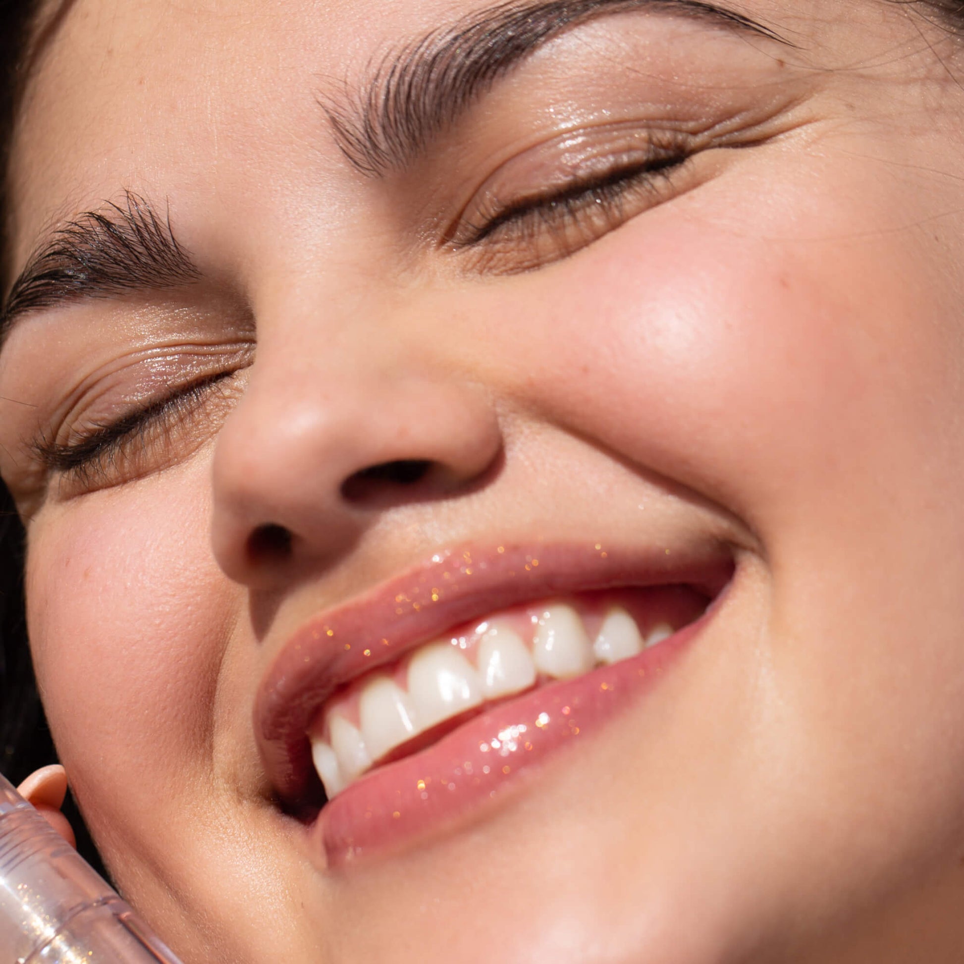 A model wearing the Tower 28 Beauty ShineOn Lip Jelly in the shade Magic on her lips