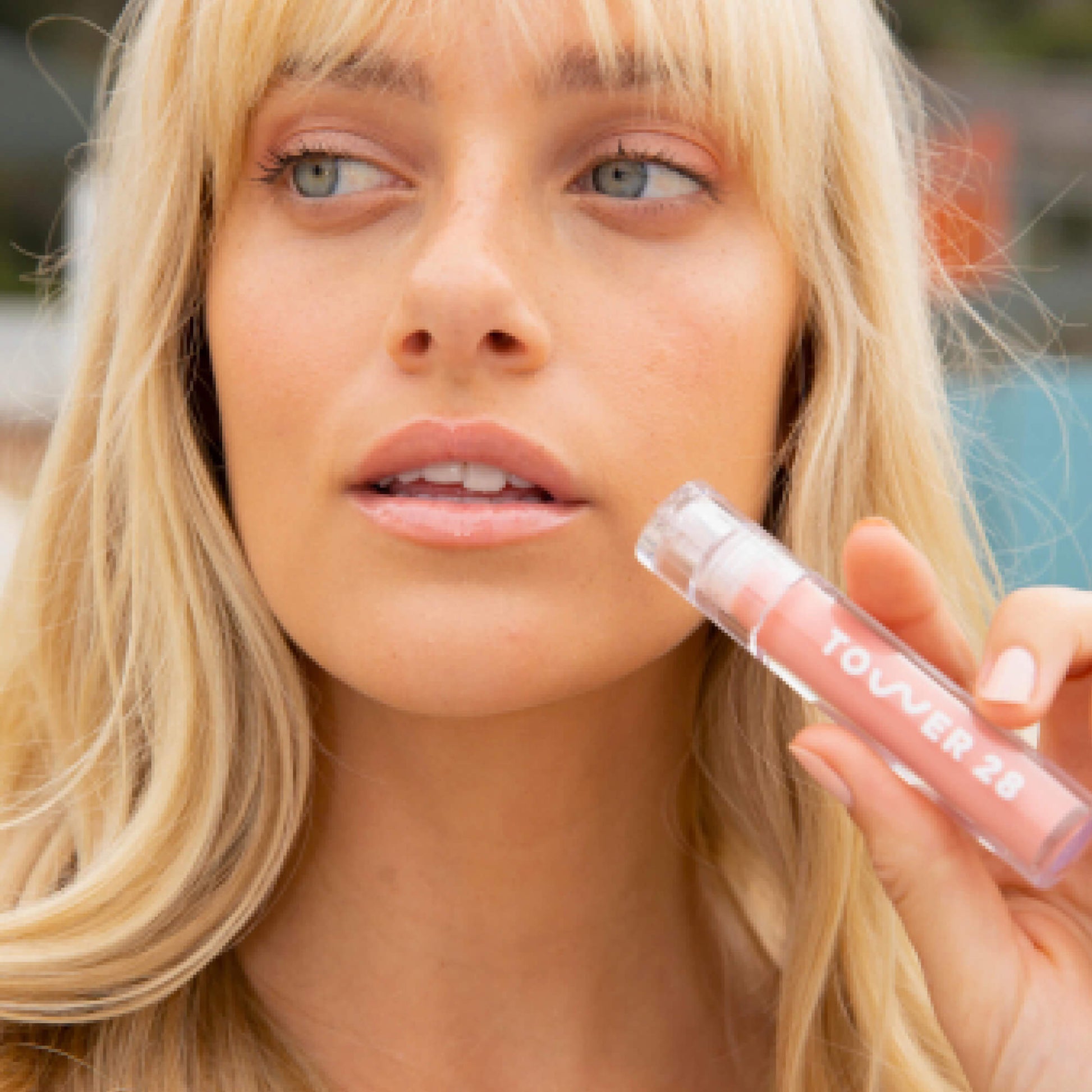 A model wearing the Tower 28 Beauty ShineOn Lip Jelly in the shade Oat on her lips