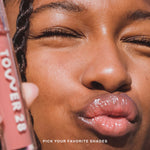 Close-up of a person with a pink lip gloss and Tower 28 product in the background [Shared]