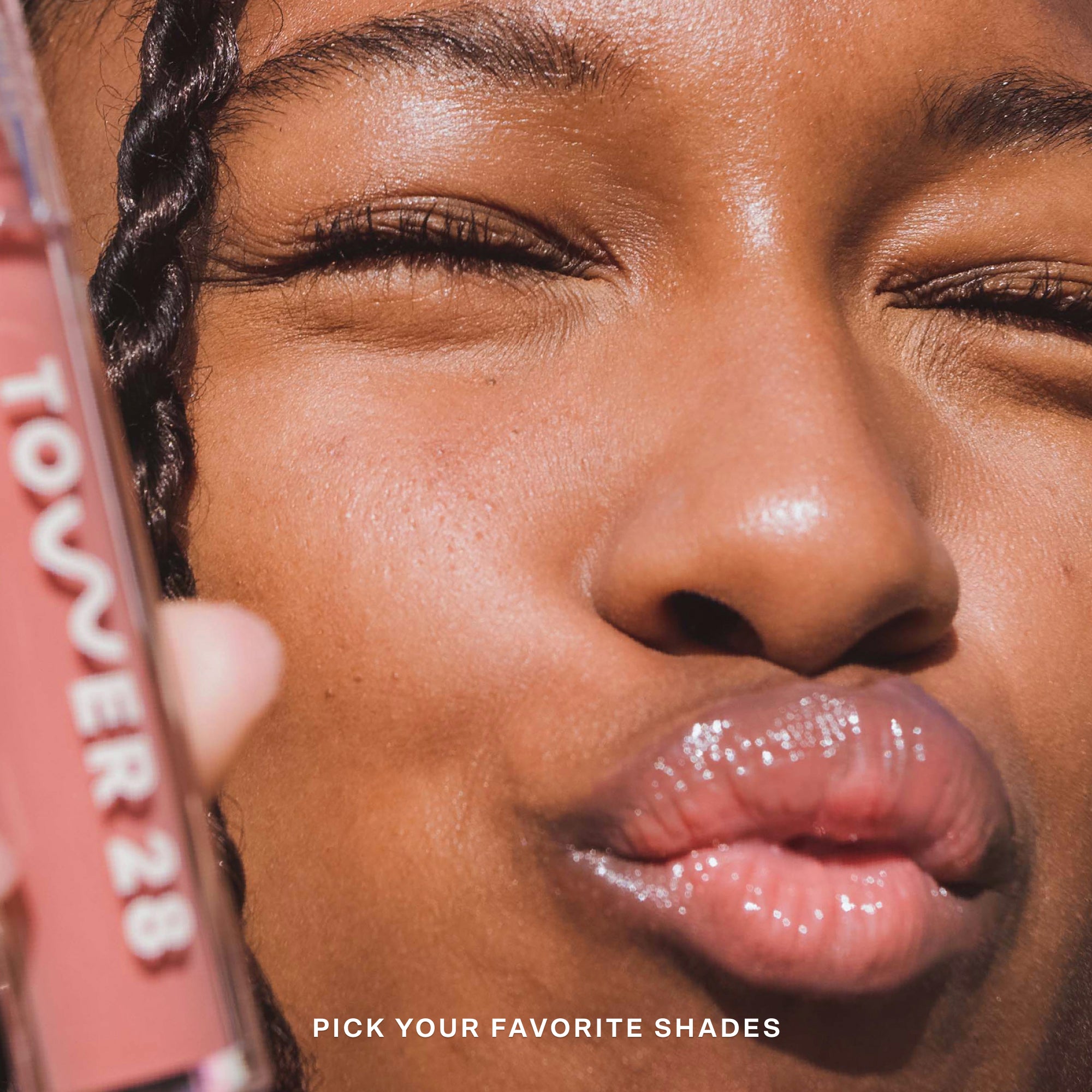 Close-up of a person with a pink lip gloss and Tower 28 product in the background [Shared]