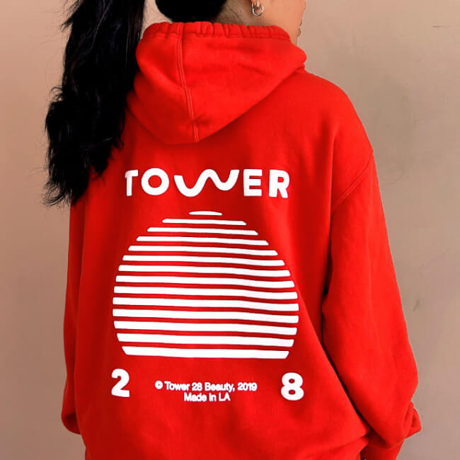 Shared: Tower 28 Beauty's SOS Hoodie in sunset orange where all proceeds are donated to Heal The Bay.
