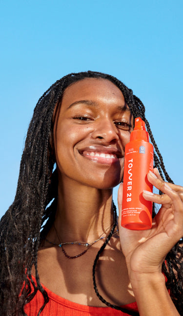 [A model holding the Tower 28 Beauty SOS Rescue Spray in hand.]