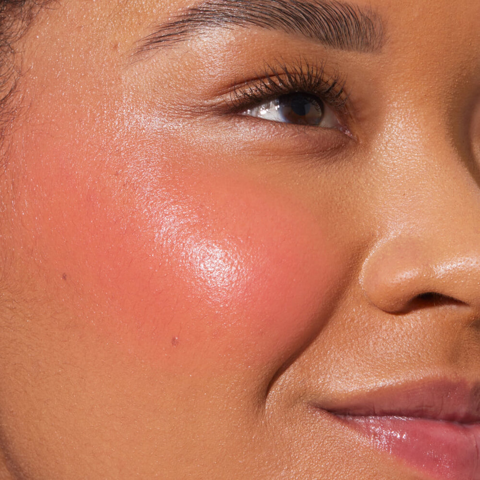 A close up of a model with Tower 28 Beauty's BeachPlease Cream Blush in Happy Hour on her face.