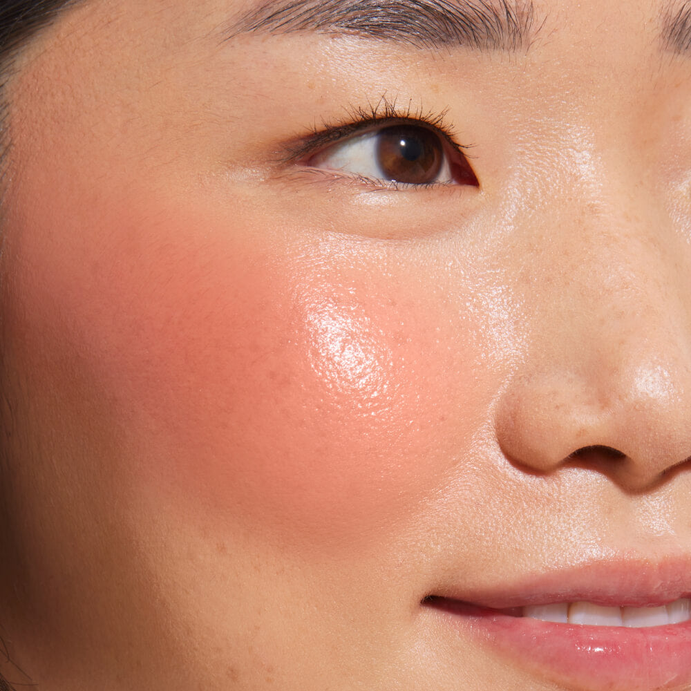 A close up of a model with Tower 28 Beauty's BeachPlease Cream Blush in Power Hour on her face.