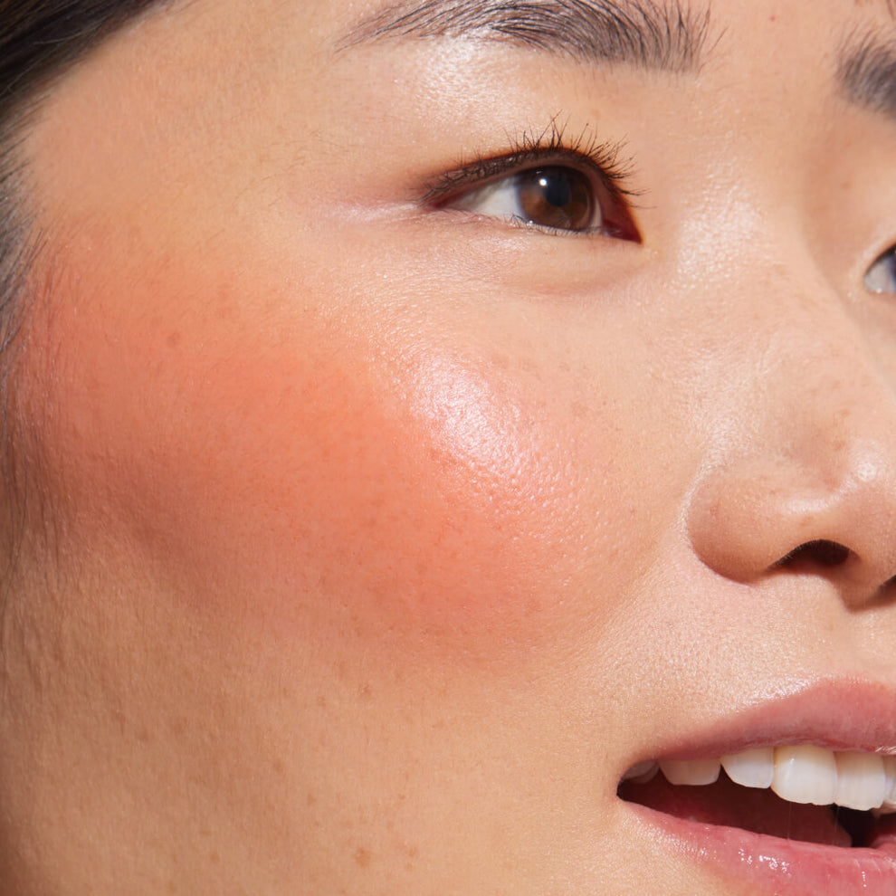 A close up of a model with Tower 28 Beauty's BeachPlease Cream Blush in Rush Hour on her face.