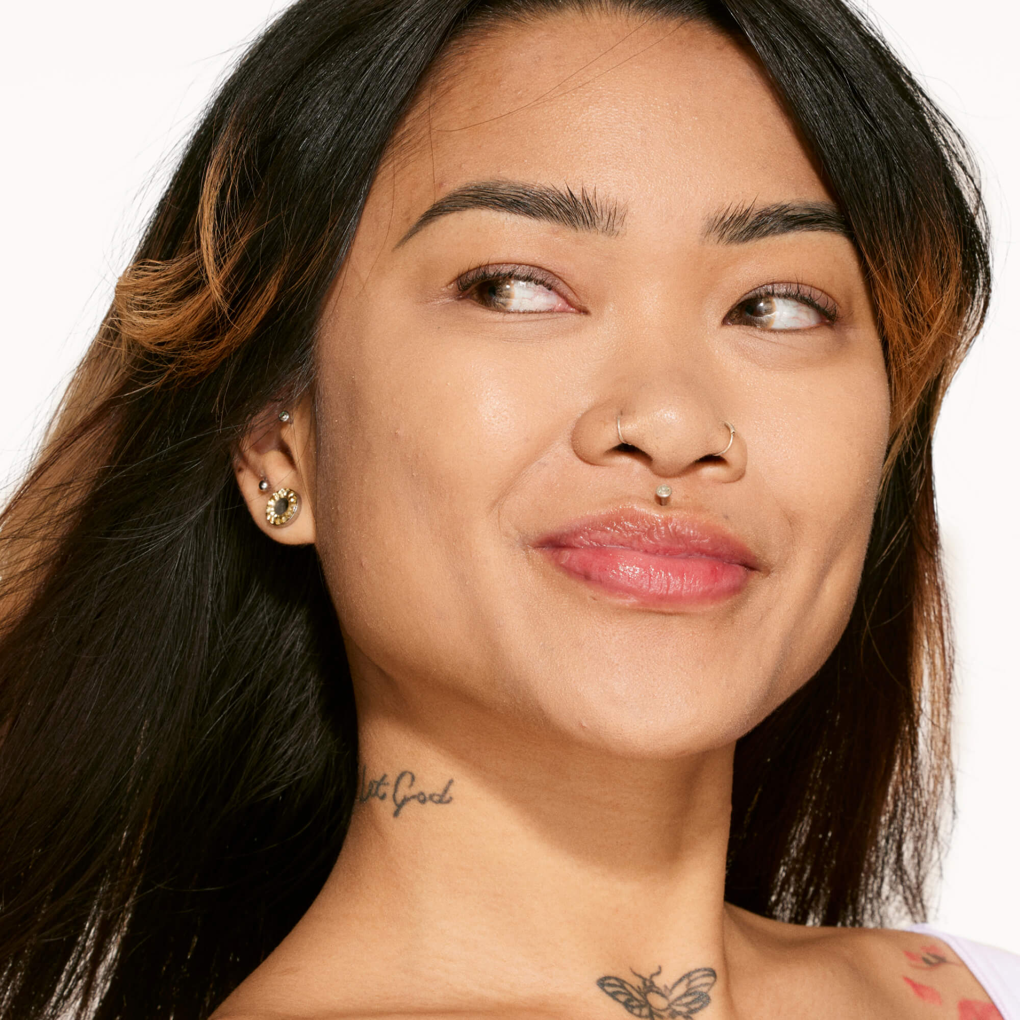 A person shown wearing Tower 28 Beauty's Swipe Serum Concealer in shade 10.0 NOHO, with an evened skin tone and natural-looking finish. [10.0 NOHO]
