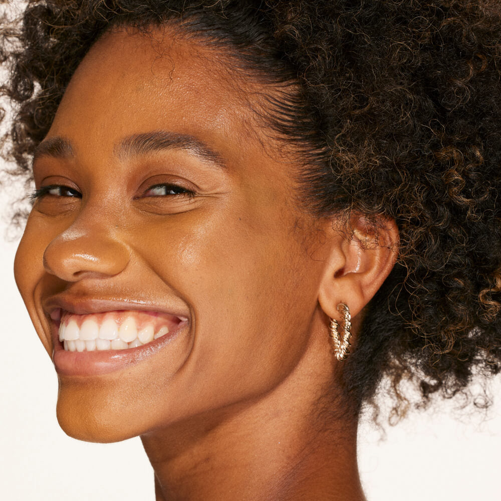 A person's face with an evened out complexion after using Tower 28 Beauty's Swipe Serum Concealer in shade 14.0 PV. [14.0 PV]