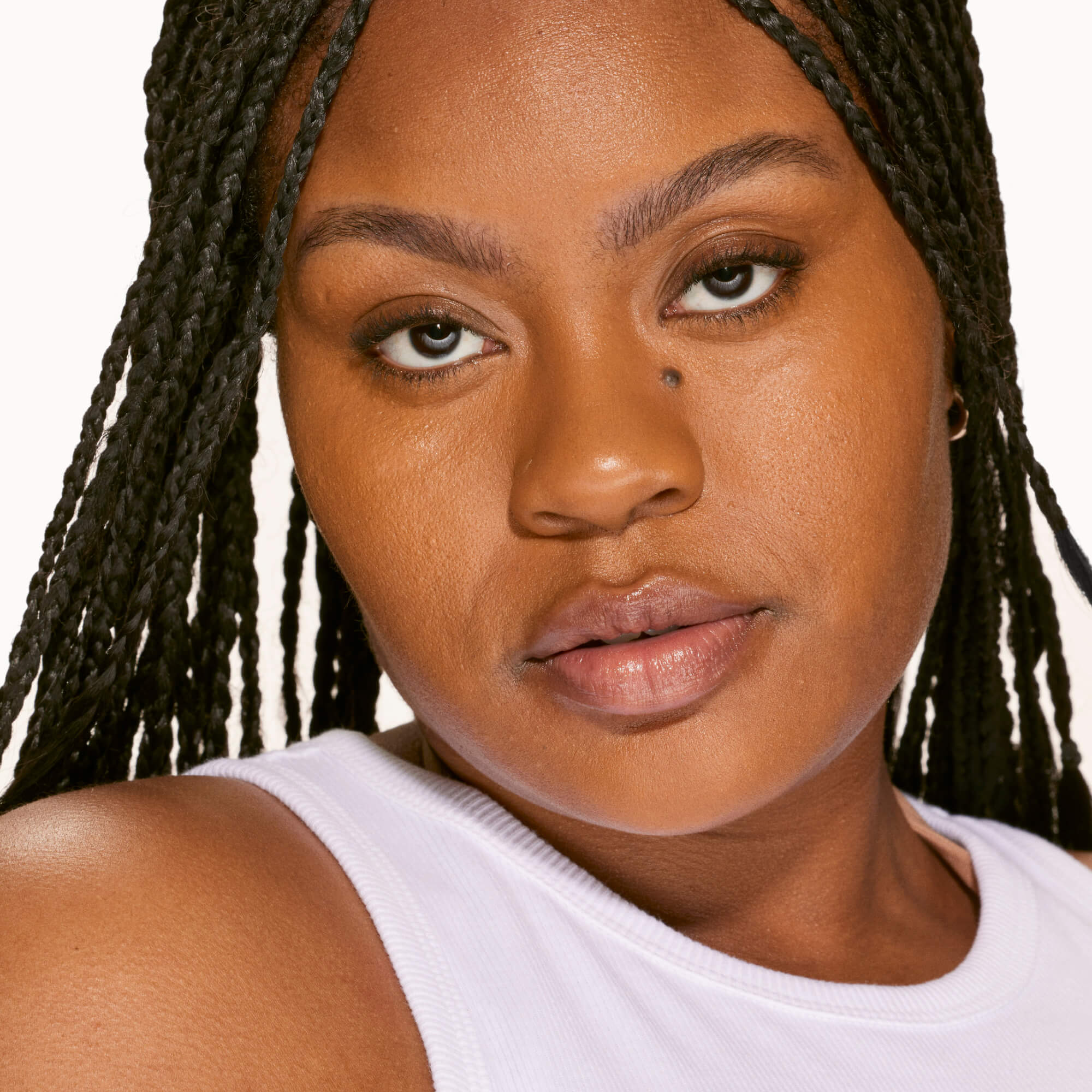 A person's face with an evened out complexion after using Tower 28 Beauty's Swipe Serum Concealer in shade 15.0 SAMO. [15.0 SAMO]