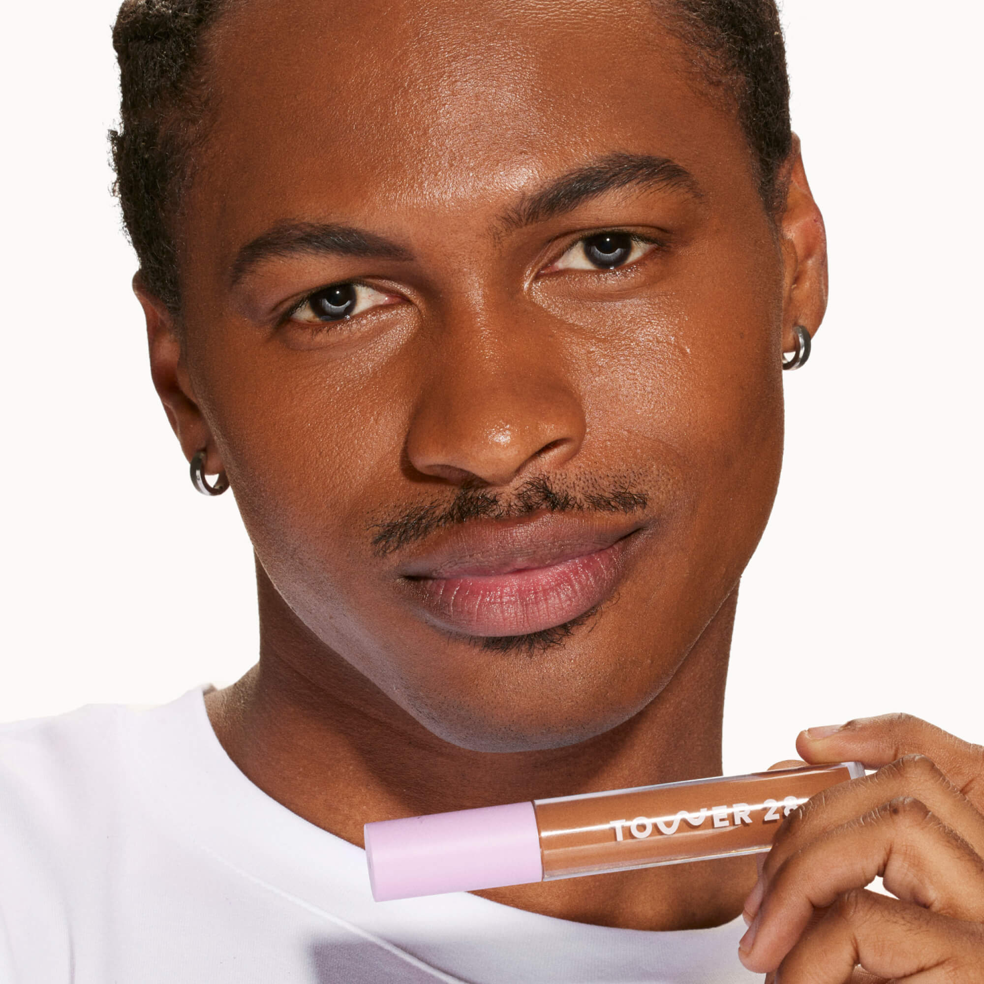 A person's face with an evened out complexion after using Tower 28 Beauty's Swipe Serum Concealer in shade 17.0 SD. [17.0 SD]