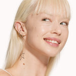 A person wearing Tower 28 Beauty's Swipe Serum Concealer in shade 2.0 BU, shown with an even, dewy finish and natural coverage across the cheeks and under-eyes. [2.0 BU]