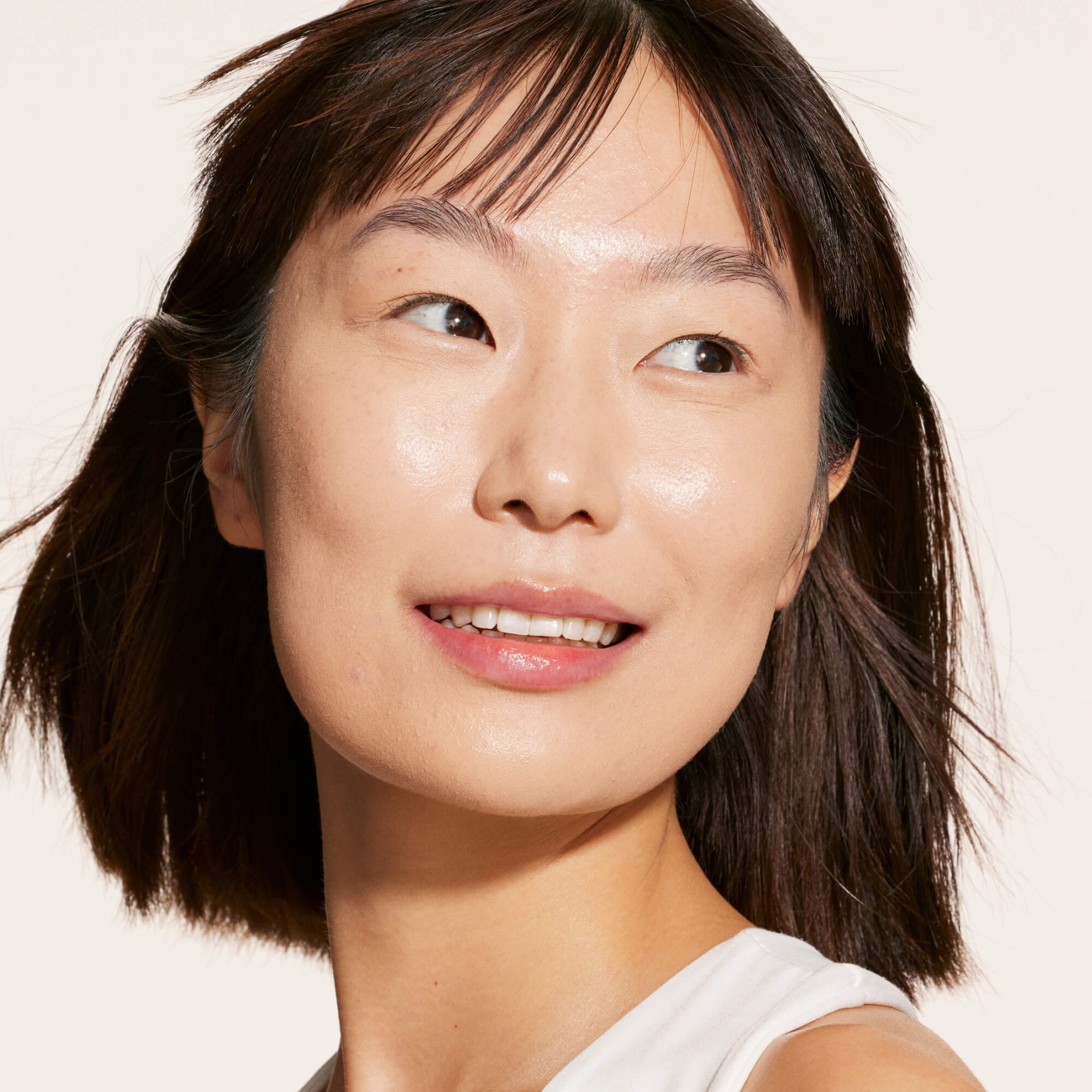A person wearing Tower 28 Beauty's Swipe Serum Concealer in shade 4.0 DTLA, shown with a radiant, even-toned complexion and a natural, skin-like finish. [4.0 DTLA]