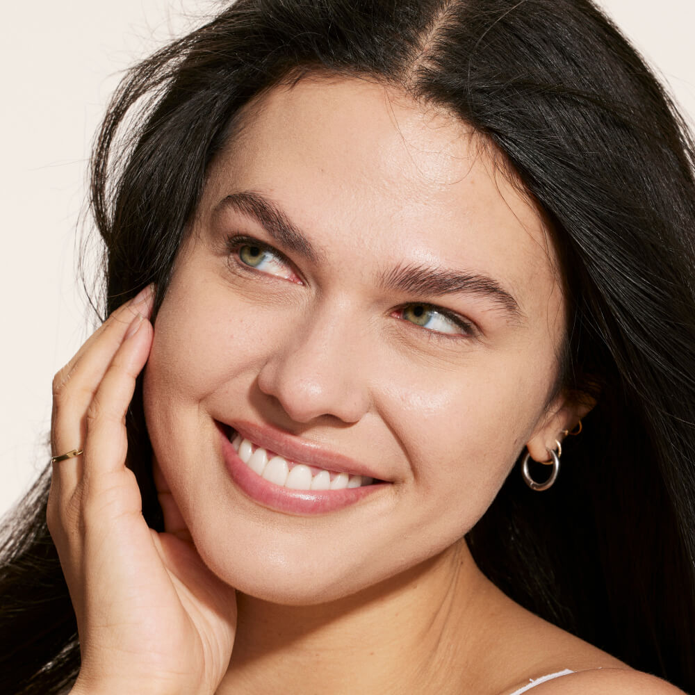 A person wearing Tower 28 Beauty's Swipe Serum Concealer in shade 5.0 EP, shown with a smooth, natural finish and radiant complexion. [5.0 EP]