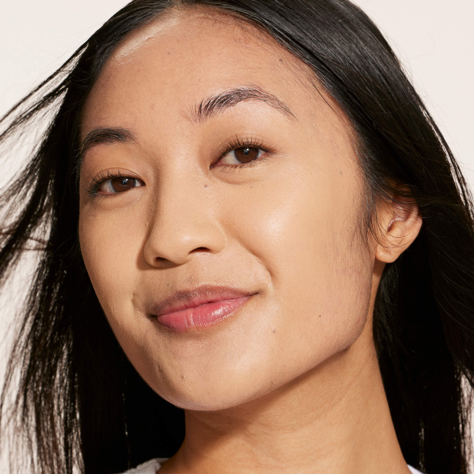 A person wearing Tower 28 Beauty's Swipe Serum Concealer in shade 8.0 LBC, shown with an evened-out complexion and smooth, natural finish. [8.0 LBC]