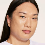 A person wearing Tower 28 Beauty's Swipe Serum Concealer in shade 9.0 MDR, shown with an even complexion, smooth coverage, and reduced redness. [9.0 MDR]