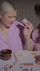 Tower 28 Beauty Holiday Drip 2023 Campaign - Video Montage of 2 Girls Applying ShineOn Lip Jelly and eating Tower 28 x DEUX Cookie Butter Drip, Wearing the purple Tower 28 x Comfy Original Wearable Blanket, and Tower 28 Toasty Toes Socks 