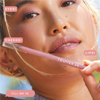 Shade: Fill Me In [A model wearing the Tower 28 Beauty OneLiner in the shade Fill Me In on her lips, cheeks, and eyes]