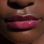 A model wearing the Tower 28 Beauty ShineOn Lip Jelly in the shade XOXO on her lips. [XOXO]
