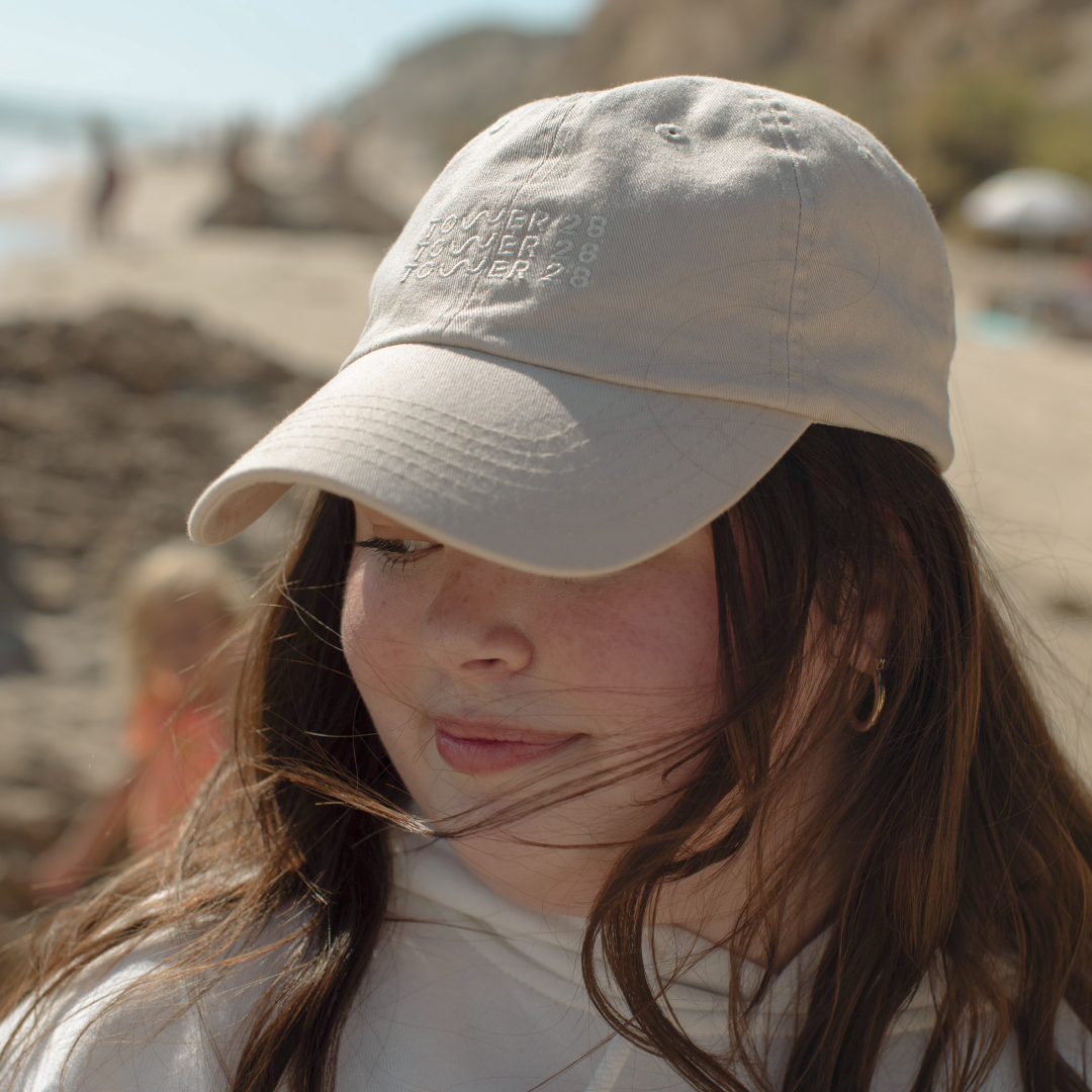 [Shared: Girl wearing Tower 28 Beauty Classic Baseball Cap Embroidered Baseball Hat with Adjustable Closure in Oatmeal Cream Color]