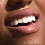 [Shared: Closeup photo of very glossy lips, smiling and wearing the Tower 28 Beauty ShineOn Milky Lip Jelly shade in Oat (a milky peachy-pink)]