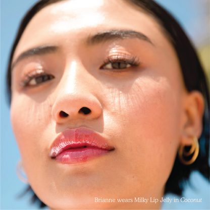 Coconut [Closeup photo of a girl with very glossy lips, wearing the Tower 28 Beauty ShineOn Milky Lip Jelly shade in Coconut (a milky mauve-pink)]